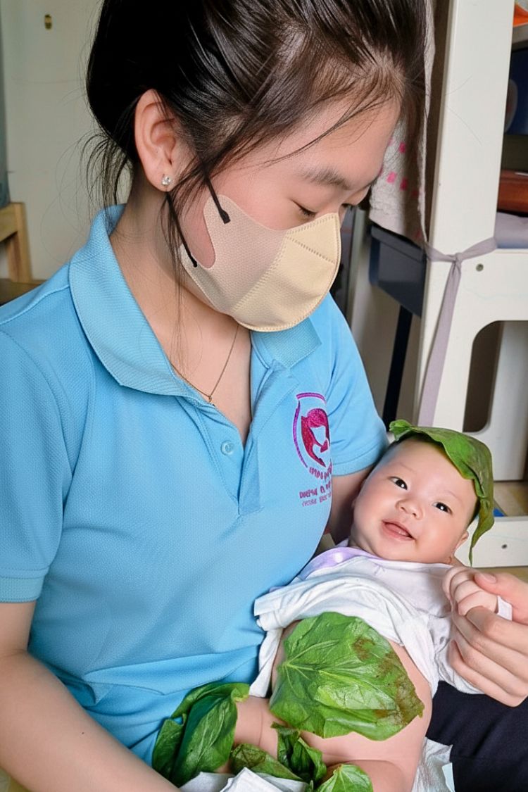 Em bé đáng yêu được hơ lá trầu sau khi tắm bé